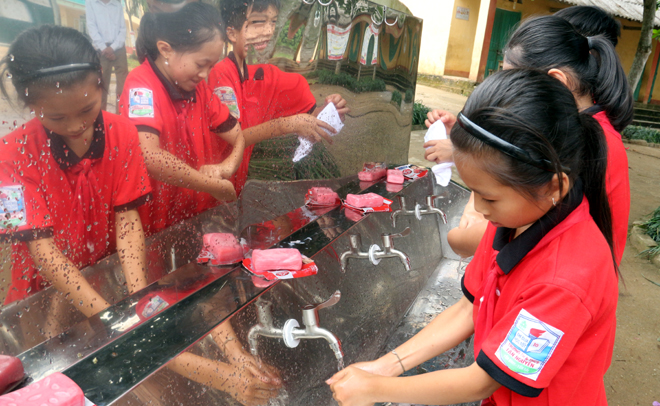 Các em học sinh Trường Tiểu học và Trung học cơ sở Tân Nguyên, huyện Yên Bình rửa tay sạch sẽ trước khi vào lớp và sau khi ra chơi.
